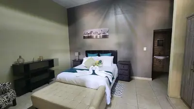 a bedroom with a large bed and a sink at Koi Inn in Hartbeespoort