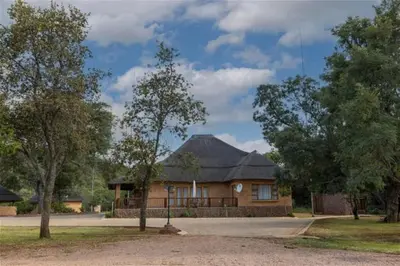 a house with a gambrel roof in a park at Lichenry Bush Lodge in Mokopane