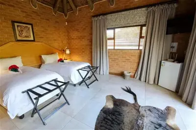 a bedroom with two beds and a large window at Lichenry Bush Lodge in Mokopane