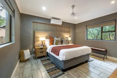 a bedroom with a large bed and a window at Wildheart Safari - Zesty Zebra in Hoedspruit