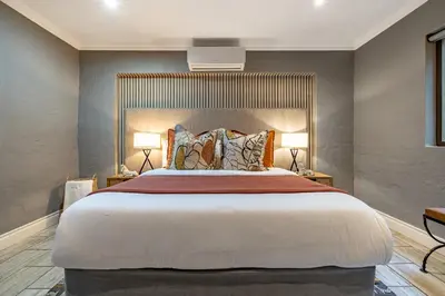 a bedroom with a large bed with two lamps at Wildheart Safari - Zesty Zebra in Hoedspruit