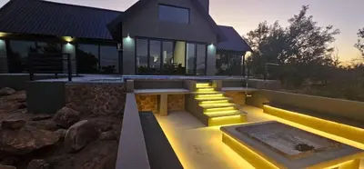 a home with a lit up patio with a table at Thabanyane Private Lodge Mabalingwe in Bela-Bela