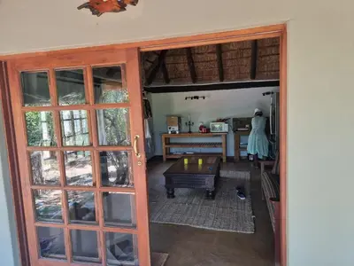 an open door to a kitchen with a table at Milkwood Cottage Mabalingwe in Bela-Bela