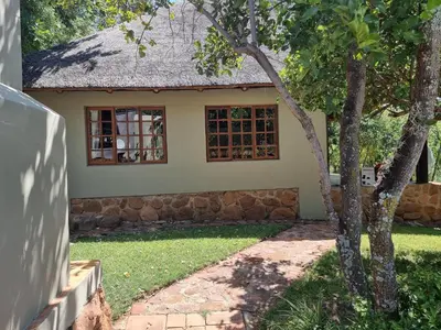 a small house with a tree in front of it at Milkwood Cottage Mabalingwe in Bela-Bela