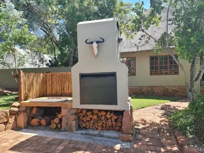 a statue of a goat sitting on top of a fireplace at Milkwood Cottage Mabalingwe in Bela-Bela