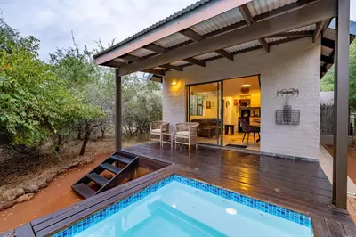 a patio with a swimming pool and a house at Wildheart Safari - Lion's Den in Hoedspruit