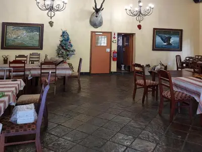 a restaurant with tables and chairs and a christmas tree at Waterfall Safari Lodge in Winterkamp