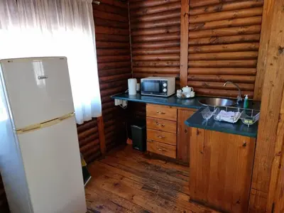 a kitchen with a white refrigerator and a sink at Waterfall Safari Lodge in Winterkamp