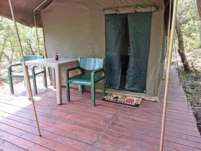 a tent with a table and chairs on a deck at Waterfall Safari Lodge in Winterkamp