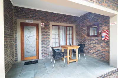a table and chairs sitting next to a brick wall at Stevenski's Guesthouse in Lephalale