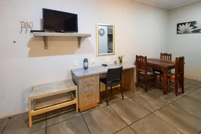 a room with a desk and a table with chairs at Stevenski's Guesthouse in Lephalale