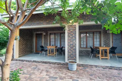 a brick building with tables and chairs on a patio at Stevenski's Guesthouse in Lephalale
