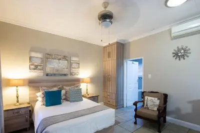 a bedroom with a bed and a chair at Stevenski's Guesthouse in Lephalale