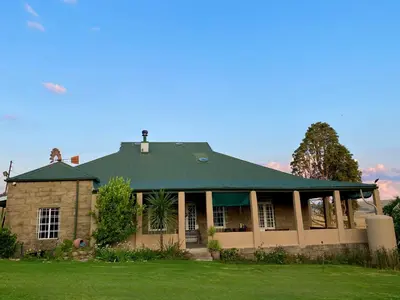 a house with a green roof on a lawn at Echo Valley Guest Farm in Breyten