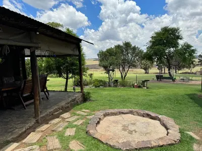 a garden with a stone circle in the grass at Echo Valley Guest Farm in Breyten