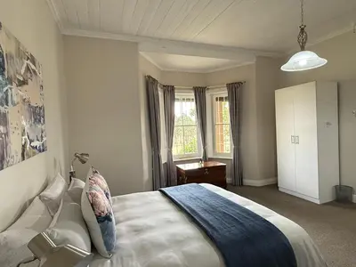 a bedroom with a large bed and a window at Echo Valley Guest Farm in Breyten