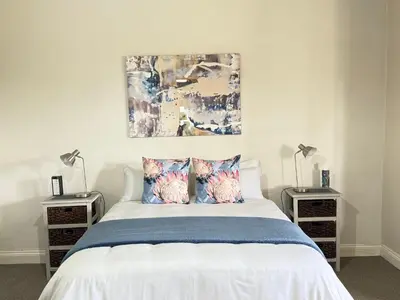 a bedroom with a white bed with two night stands at Echo Valley Guest Farm in Breyten
