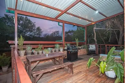 a wooden deck with a picnic table and a grill at Bushbaby Cottage with Tickle Tub in Hartbeespoort in Pretoria