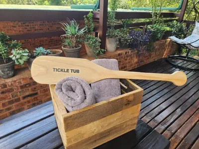 a wooden box with a towel holder on a deck at Bushbaby Cottage with Tickle Tub in Hartbeespoort in Pretoria