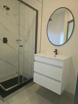a bathroom with a shower and a sink and a mirror at Waterfall Apartments Waterfall Cres in Midrand
