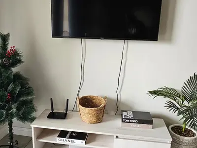 a tv on a wall above a white table with a christmas tree at Waterfall Apartments Waterfall Cres in Midrand