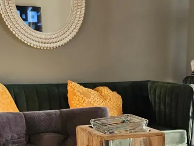 a living room with a green couch and a mirror at Waterfall Apartments Waterfall Cres in Midrand