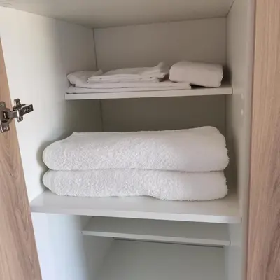 a closet with white towels sitting on shelves at Waterfall Apartments Waterfall Cres in Midrand