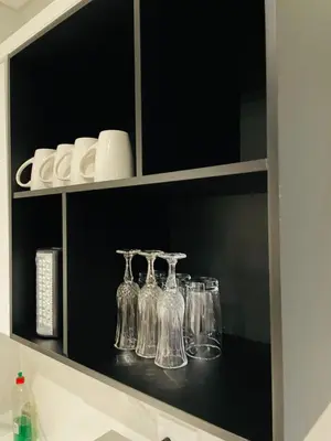 a shelf with glass bottles and cups on it at Waterfall Apartments Waterfall Cres in Midrand