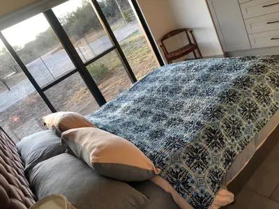 a bedroom with a bed with pillows and a window at Barn Owl Lodge, Mjejane Game Reserve, Greater Kruger Park in Hectorspruit