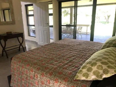 a bedroom with a bed and a view of a patio at Barn Owl Lodge, Mjejane Game Reserve, Greater Kruger Park in Hectorspruit