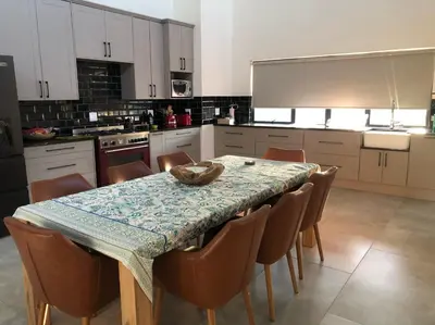 a kitchen with a table with chairs and a counter top at Barn Owl Lodge, Mjejane Game Reserve, Greater Kruger Park in Hectorspruit