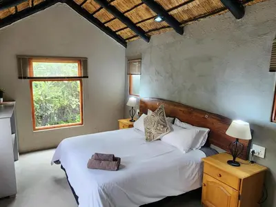 a bedroom with a large white bed with a window at African Sky Bush Camp in Rabelaisruskamp