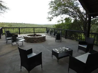a patio with a fire pit and chairs and tables at Balule Bushveld Safari Lodge in Phalaborwa