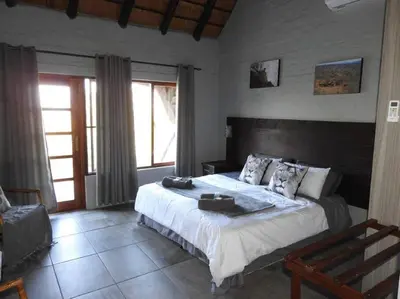 a bedroom with a large bed in a room at Balule Bushveld Safari Lodge in Phalaborwa