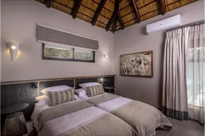 a bedroom with a large bed and a window at Simbavati Waterside in Klaserie Private Nature Reserve