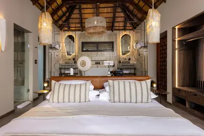 a bedroom with a large bed with two pillows at Simbavati Waterside in Klaserie Private Nature Reserve