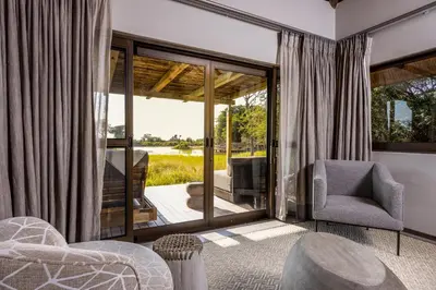 a living room with a view of a patio at Simbavati Waterside in Klaserie Private Nature Reserve