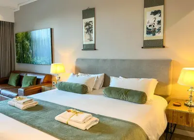 a bedroom with a large bed with towels on it at Menlyn Maine Residences - Kyoto king size xl bed in Pretoria