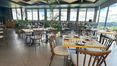 a restaurant with wooden tables and chairs and windows at Menlyn Maine Residences - Kyoto king size xl bed in Pretoria