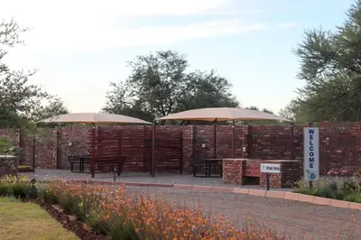two picnic tables and umbrellas in a garden at Big D Accommodation & guesthouse in Northam