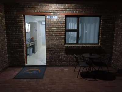 a room with a table and chairs and a brick wall at Big D Accommodation & guesthouse in Northam