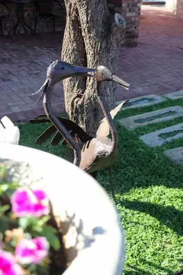a statue of a bird standing next to a tree at Big D Accommodation & guesthouse in Northam
