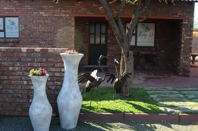 two white vases sitting in front of a brick building at Big D Accommodation & guesthouse in Northam