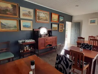 a living room with a table and a dining room at Kings B&B in Lake Chrissie