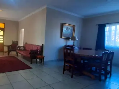 a living room with a table and chairs and a couch at Kings B&B in Lake Chrissie