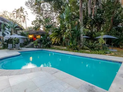 a swimming pool in a yard with a house at Royal Bakoena Hamiltonparks Country Lodge in Hazyview