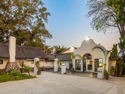 a large white house with a roof at Royal Bakoena Hamiltonparks Country Lodge in Hazyview