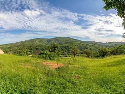 a field of grass with a mountain in the background at Royal Bakoena Hamiltonparks Country Lodge in Hazyview