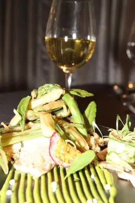a glass of wine sitting next to a plate of food at Valley View dullstroom - check in at The Highlander Hotel in Dullstroom