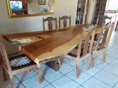 a wooden dining room table with chairs and a mirror at Hornbill Private Lodge Mabalingwe in Mabula